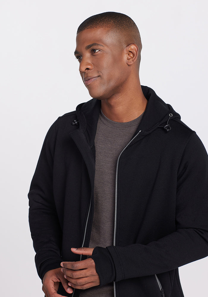 A man in a black Grizzly Sweatshirt hooded top worn over a grey crew-neck shirt.