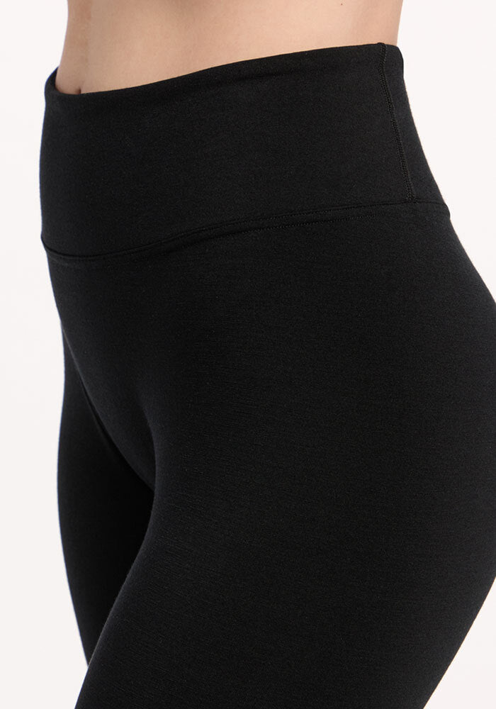 Close-up of a person wearing Woolx Angela Leggings - Black, high-waisted and comfy, against a light background.