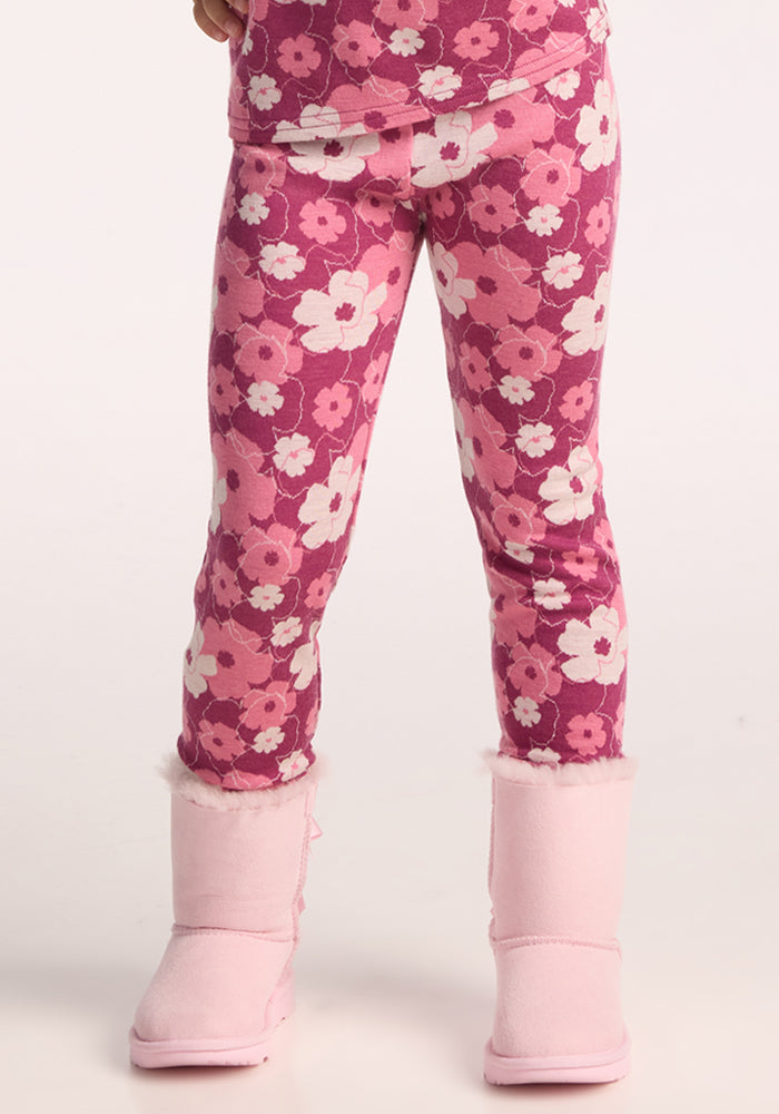 A child stands against a plain background, showing only their lower half, and wears Woolx Kids Explorer Base Layer Bottoms - Rosie Posie with light pink, fur-trimmed boots. 