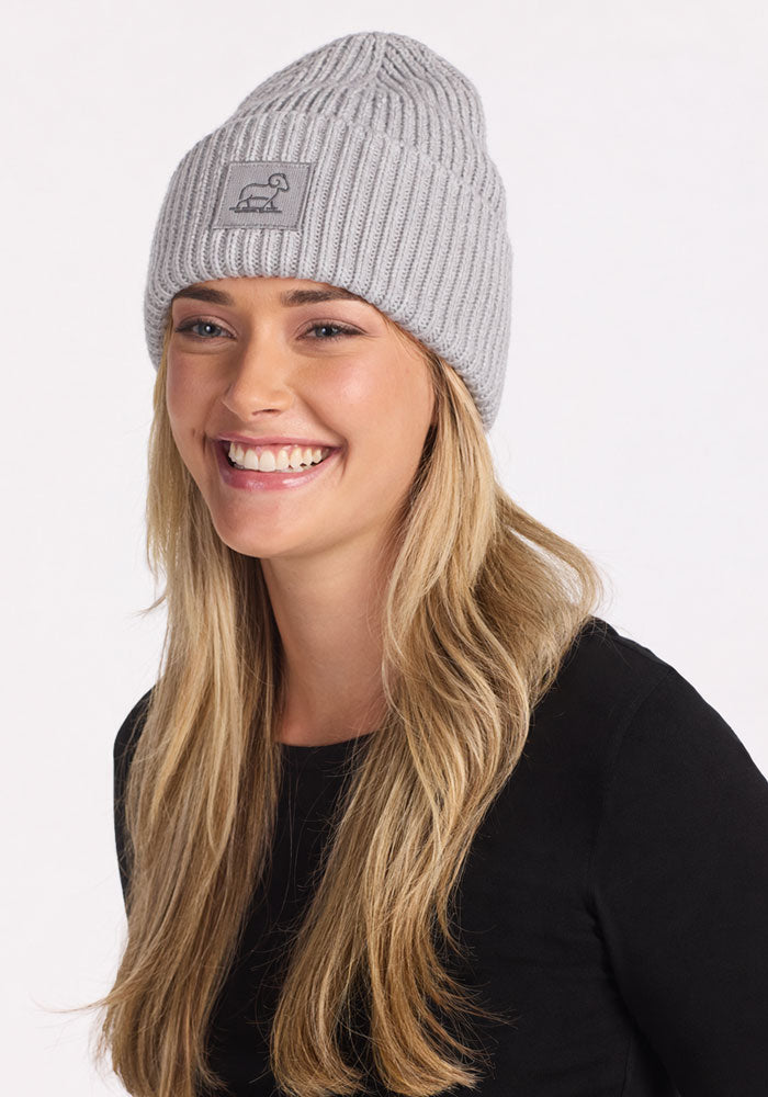 Smiling woman in the Woolx Ria Chunky Beanie - Light Ash and black shirt, posed against a white background.