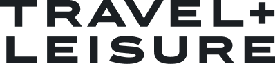 Black text reads “TRAVEL + LEISURE” in bold capital letters on a light gray background.