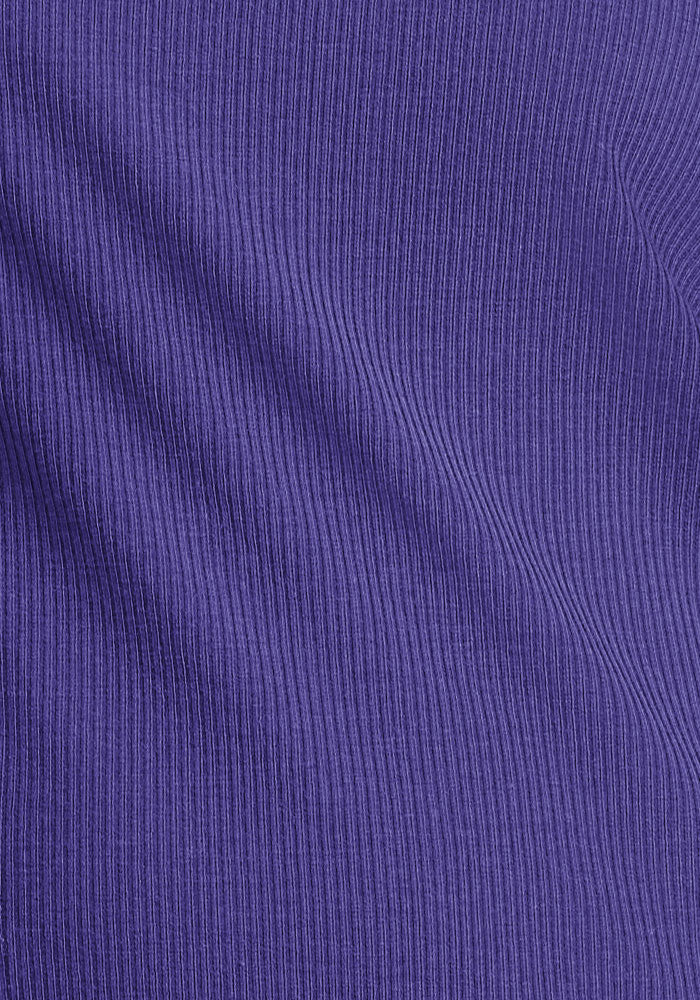 Close-up of Woolx Vera Ribbed Tunic in Berry Indigo, highlighting diagonal ribbed texture and soft merino fabric folds.
