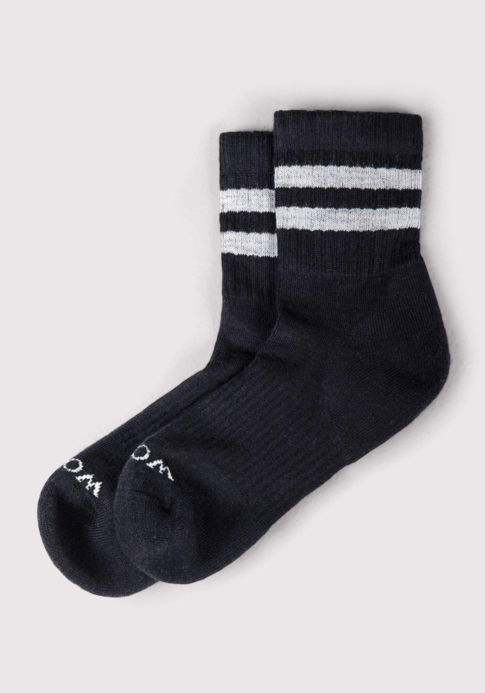 The Woolx Womens Varsity Mini Crew Socks in Black Volt feature two horizontal white stripes near the top and white toe text, shown on a light grey background.