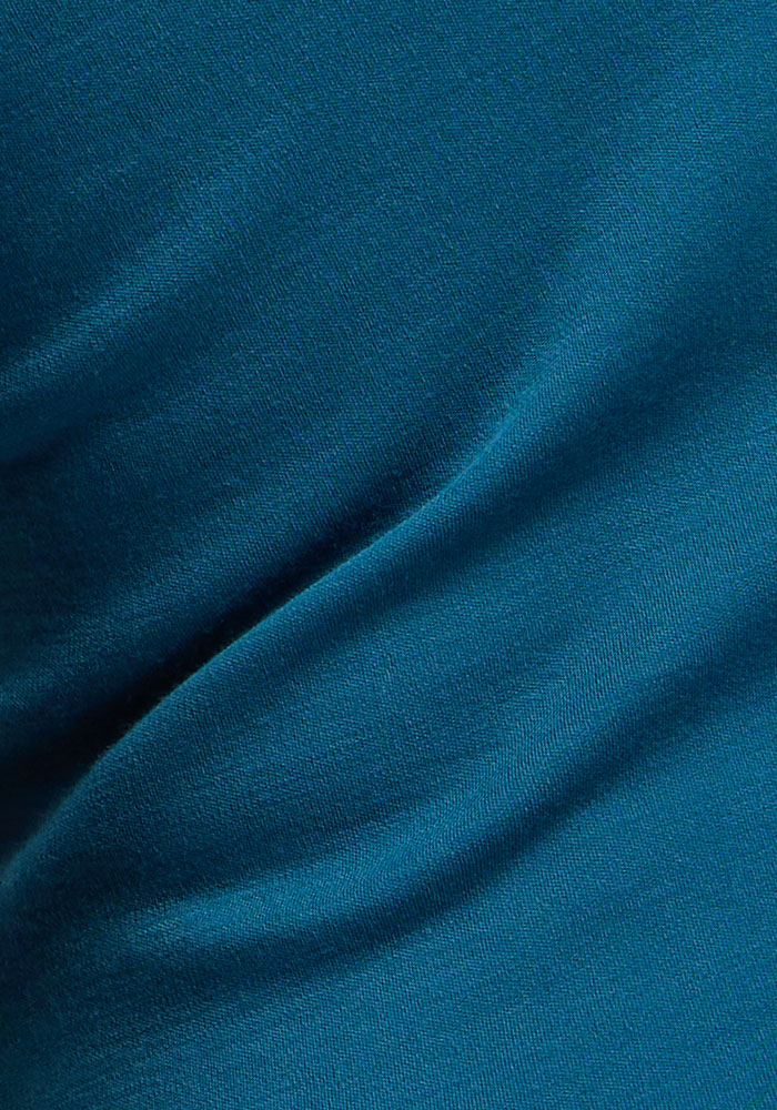 Close-up of Woolx Hannah Petite Long Sleeve Top - Blue Pine: teal moisture-wicking fabric with gentle folds.