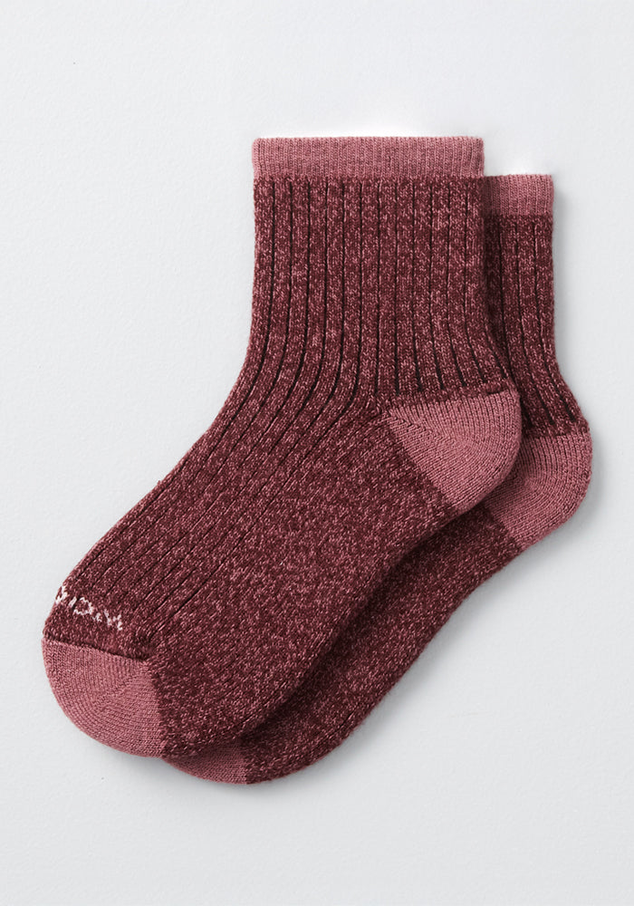 Experience ultimate comfort in the Woolx Womens Cozy Mini Crew Sock - Grape Harvest, featuring ribbed maroon Merino wool with a heathered texture and solid maroon heels, toes, and cuffs—perfectly laid out on a light gray background.
