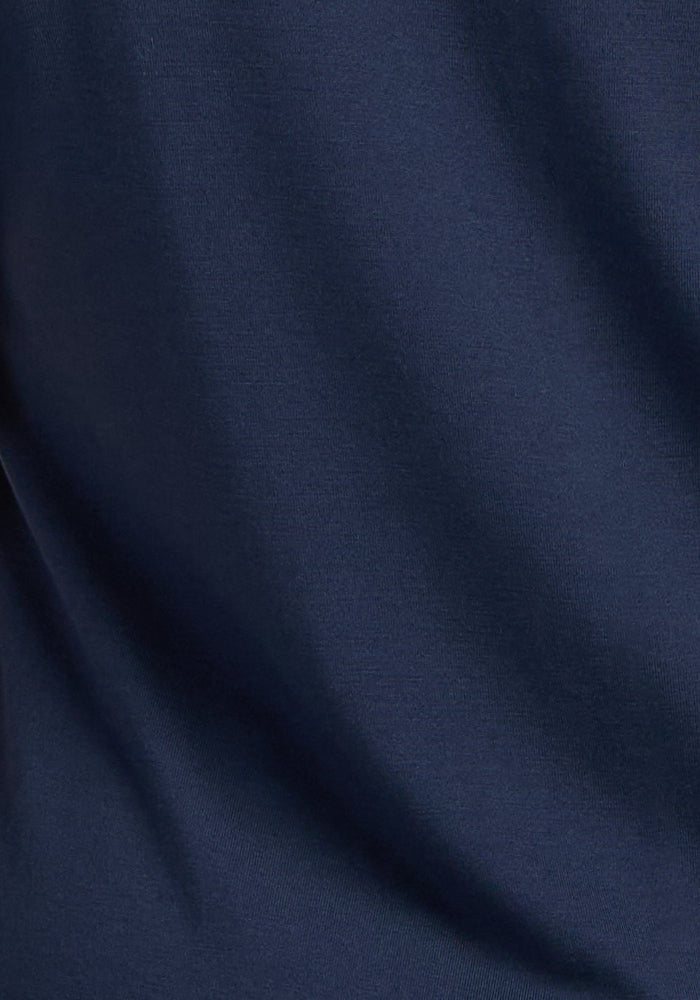 Close-up of the Woolx Georgie Dress in Deep Navy, showcasing smooth Merino wool fabric with soft folds and subtle shadows—a refined, travel-ready garment.