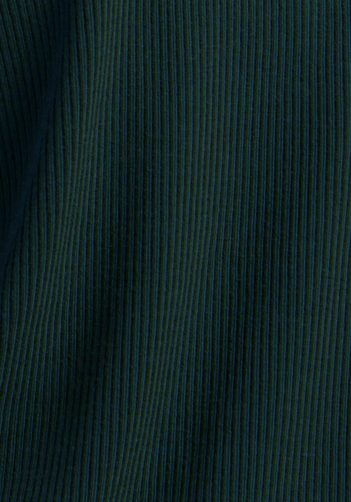 Close-up of Woolx Luca Ribbed Pants in Deep Pine highlights vertical ribbing and soft, even merino wool folds.