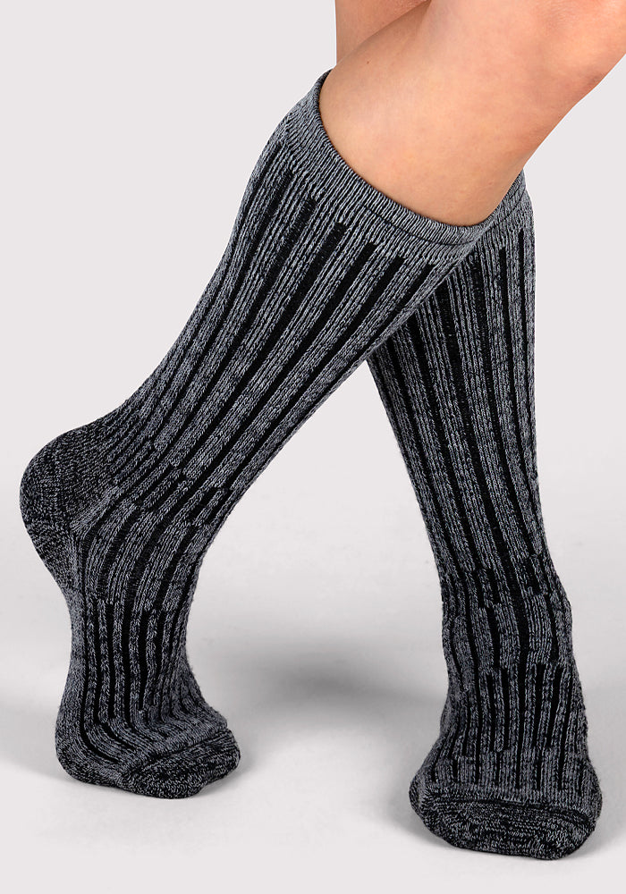 A pair of legs crossed at the ankles, wearing Woolx Womens Joey Mid Calf Socks in Dark Navy Marled against a plain light background.