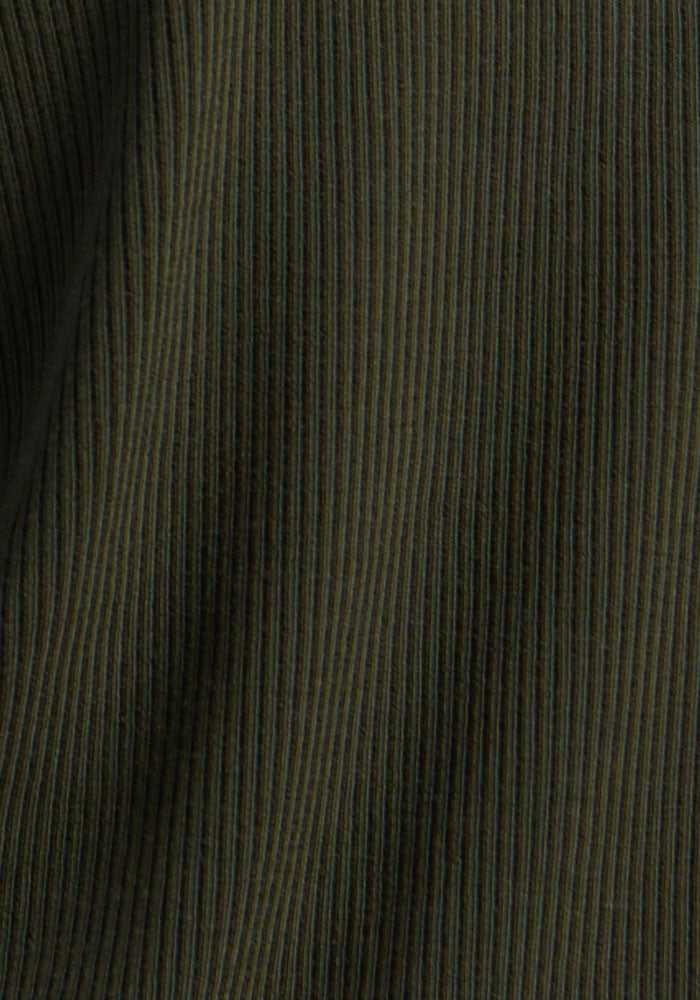Close-up of Woolx Luca Ribbed Pants - Duffel Bag: dark green Merino wool with vertical ribbed texture and soft folds.
