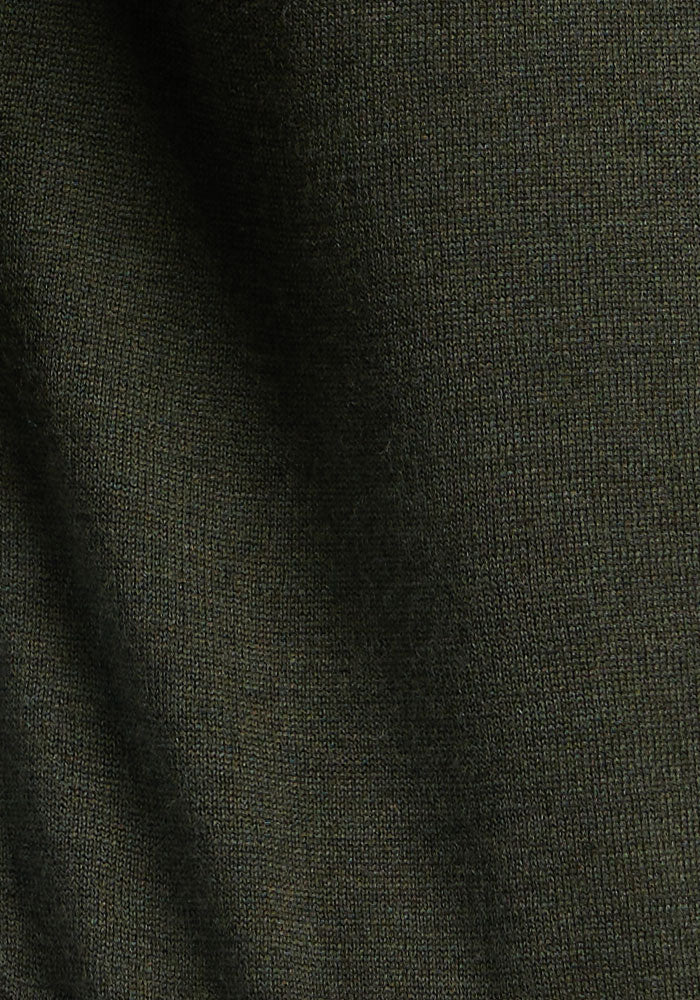 Close-up of Woolx Collins Half Zip Sweater in Duffel Bag, showing dark olive knit merino wool texture and shadow.