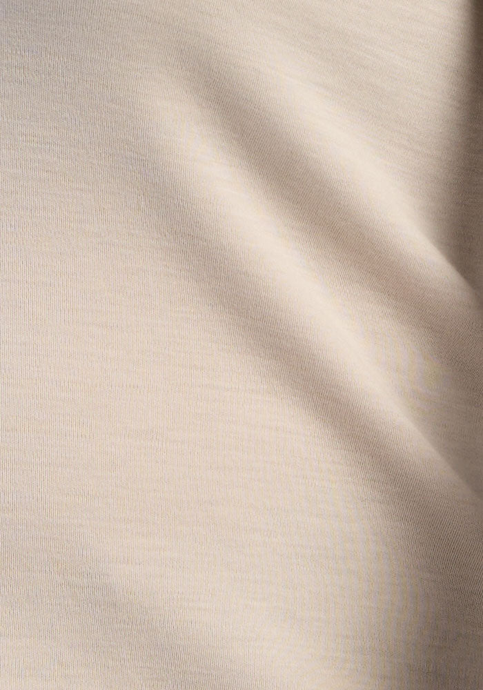 Soft, gentle ecru fabric with diagonal folds—ideal for the Woolx Blair Petite Tunic in merino wool.