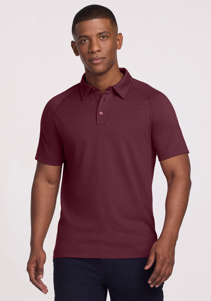 A man wearing the Woolx Summit Polo in Grape Harvest stands facing forward with a neutral expression against a plain light background. 