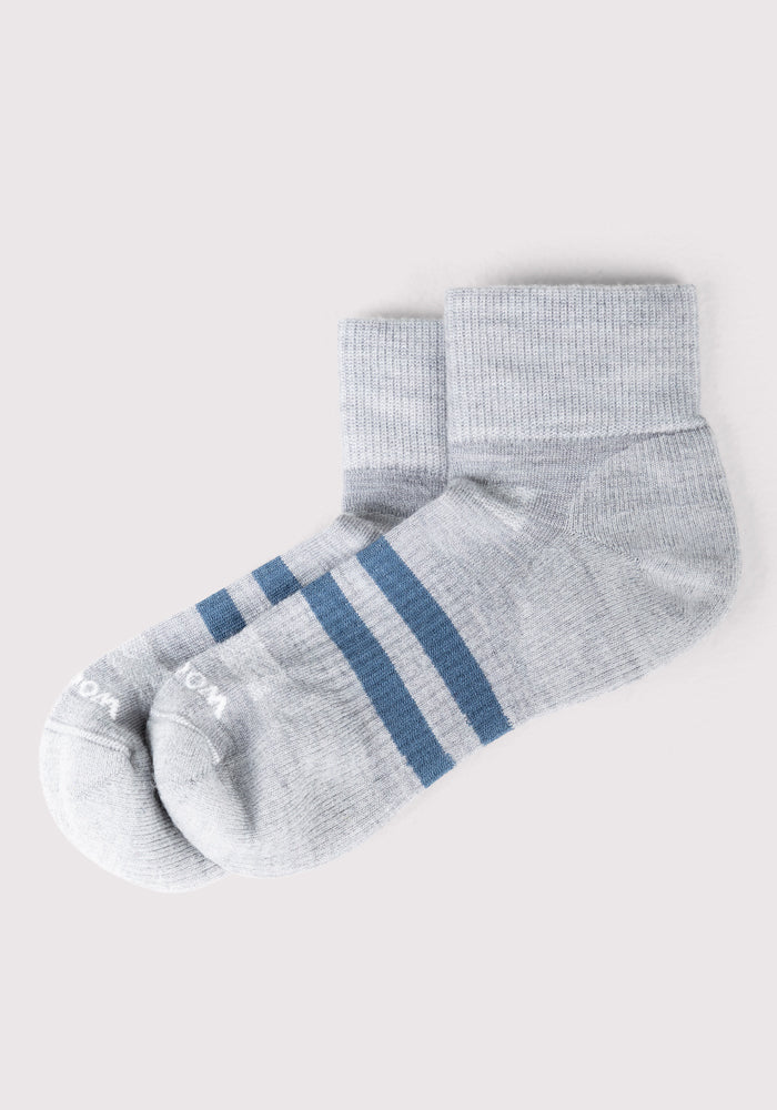 The Woolx Mens Rambler Ankle Sock in grey features two navy stripes near the ankle, offers optimal moisture management, and is showcased on a plain light background.
