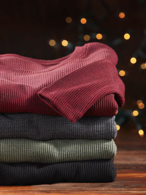 Stack of ribbed Hadley tops in front of Christmas lights