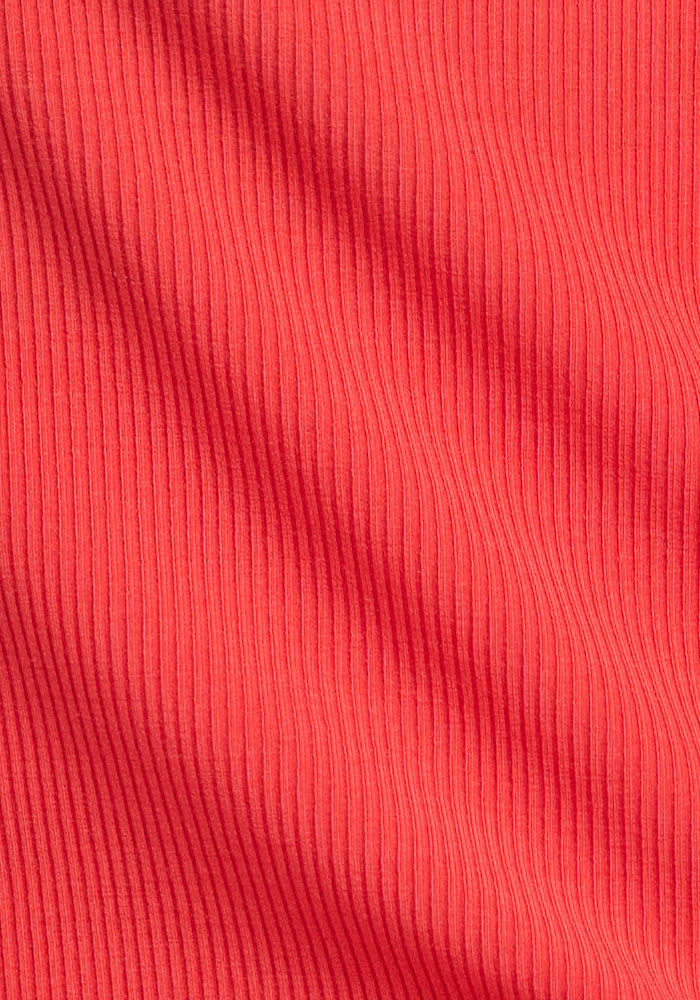 Close-up of Woolx Miley Bike Shorts - Hibiscus showing red ribbed fabric with vertical textured lines and gentle folds.