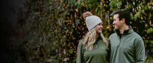 Couple wearing Woolx in front of Holiday light background