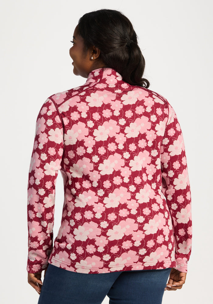 Woman facing away in Woolx Emi 1/4 Zip - Floral Crush; Merino wool, moisture wicking, odor resistant, with blue jeans.
