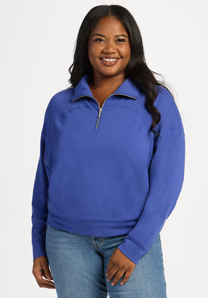 Woman wearing a royal blue Woolx Tori 1/4 Zip moisture-wicking merino wool quarter-zip. 
