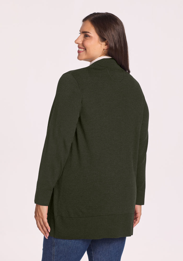 Woman smiling, facing away, in Woolx Macie Sweater - Duffel Bag and blue jeans against a light background.