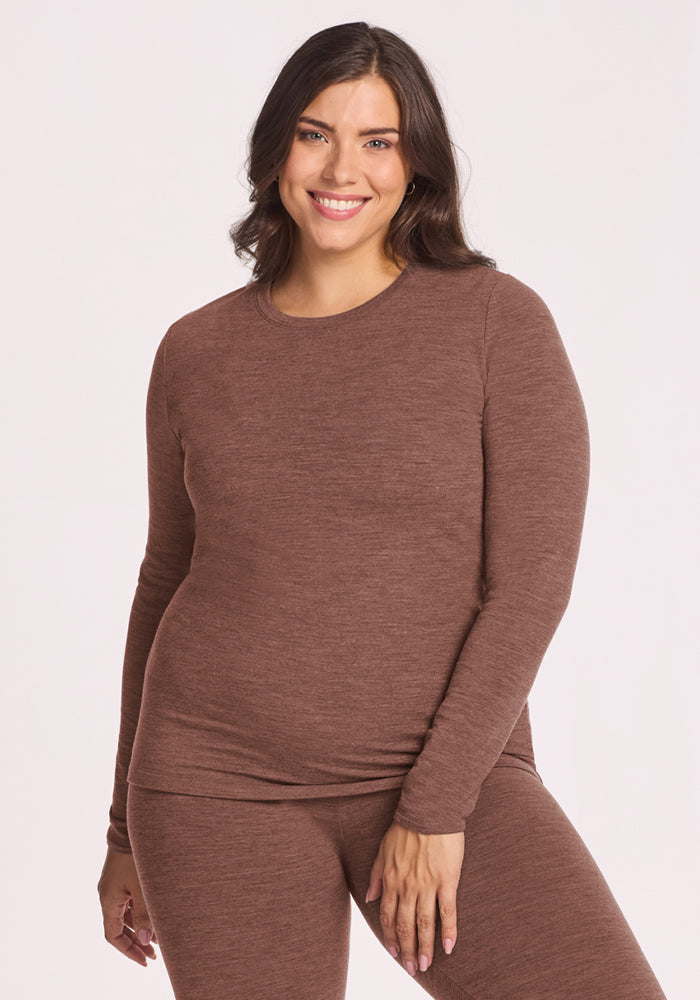 Woman wears the Woolx Sadie Baselayer Top in Sable Heather, smiling at the camera against a plain background. 