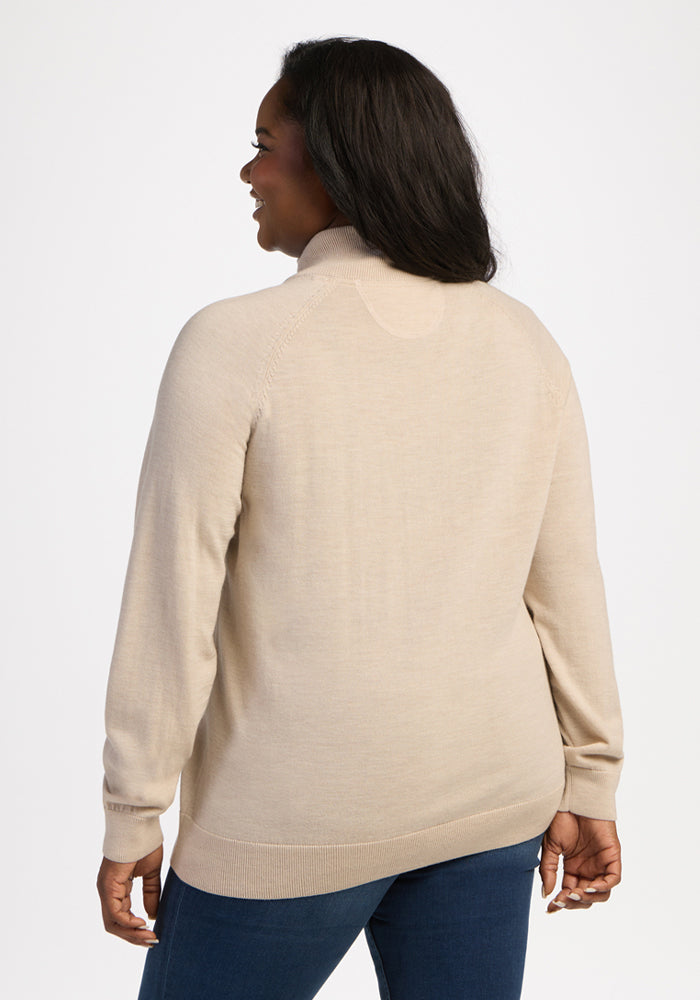 Woman in the Woolx Collins Half Zip Sweater in French Oak and blue jeans stands with her back to the camera, smiling.