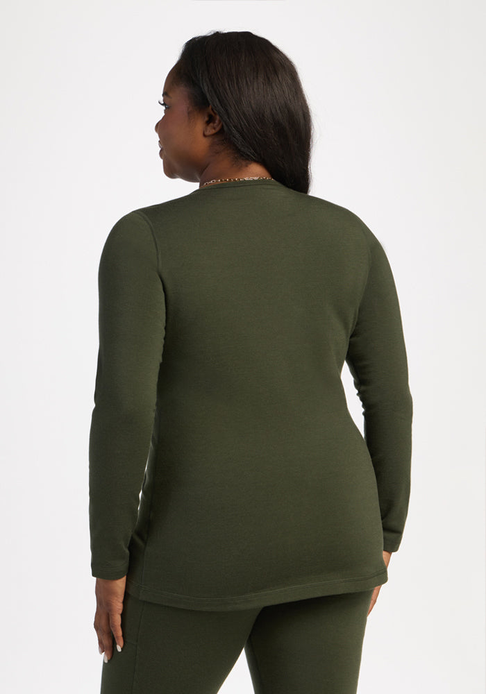 Woman wearing Woolx Elsa Long Sleeve - Duffel Bag, standing with her back to the camera in olive merino wool.
