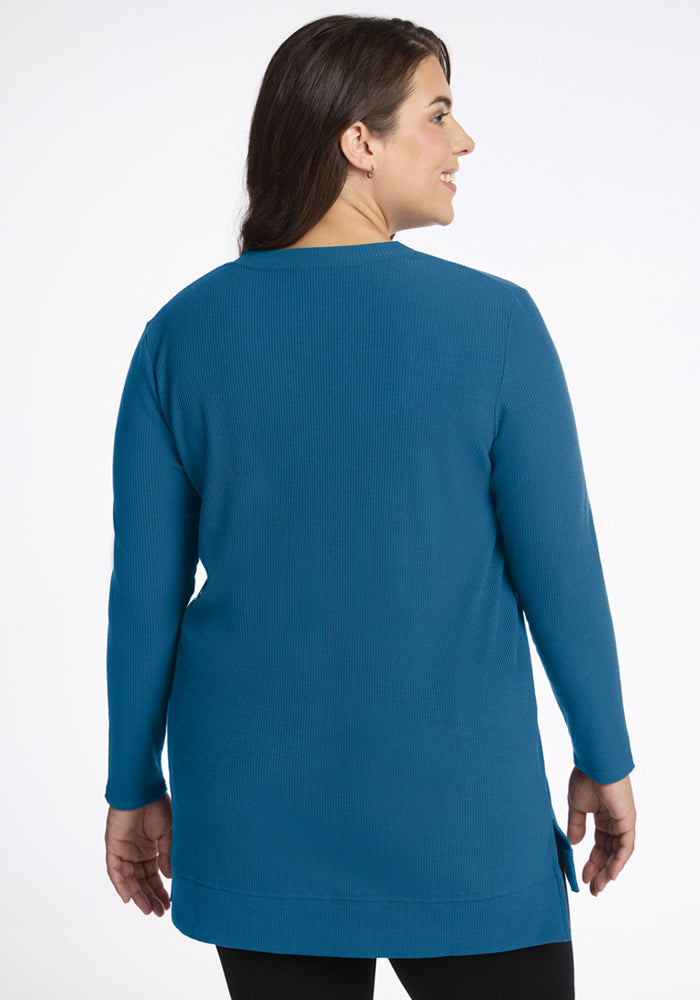 Woman facing away in Woolx Evie Ribbed Tunic - Blue Pine with black pants, on a white background.