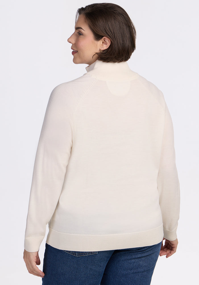 A person with short brown hair is seen from behind, wearing the Woolx Collins Half Zip Sweater in Dewdrop Pearl and blue jeans, standing against a plain white background.