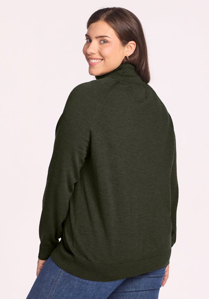 Woman in Woolx Collins Half Zip Sweater - Duffel Bag, smiling over her shoulder, paired with jeans.