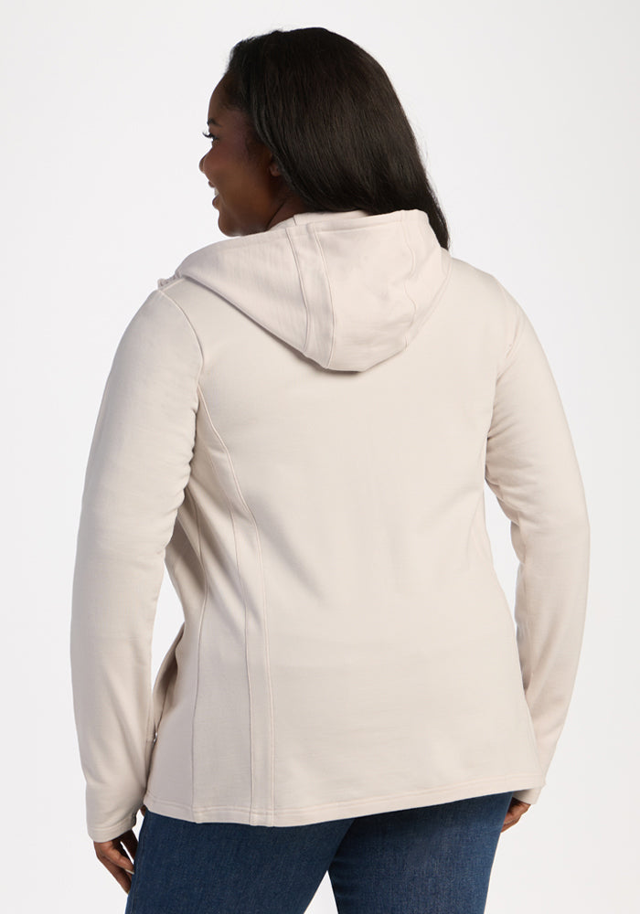 Woman in a Woolx Zoey Zip Up Hoodie - Ecru and jeans, facing away against a plain background.