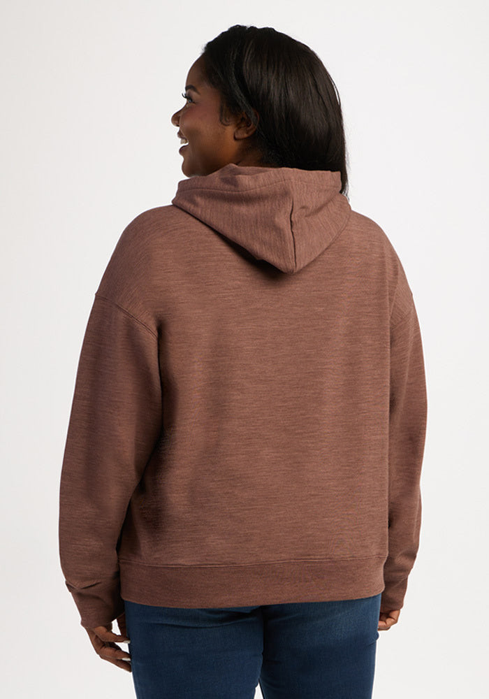 A woman seen from behind wearing a brown Genevieve Hoodie - Sable Heather and blue jeans.