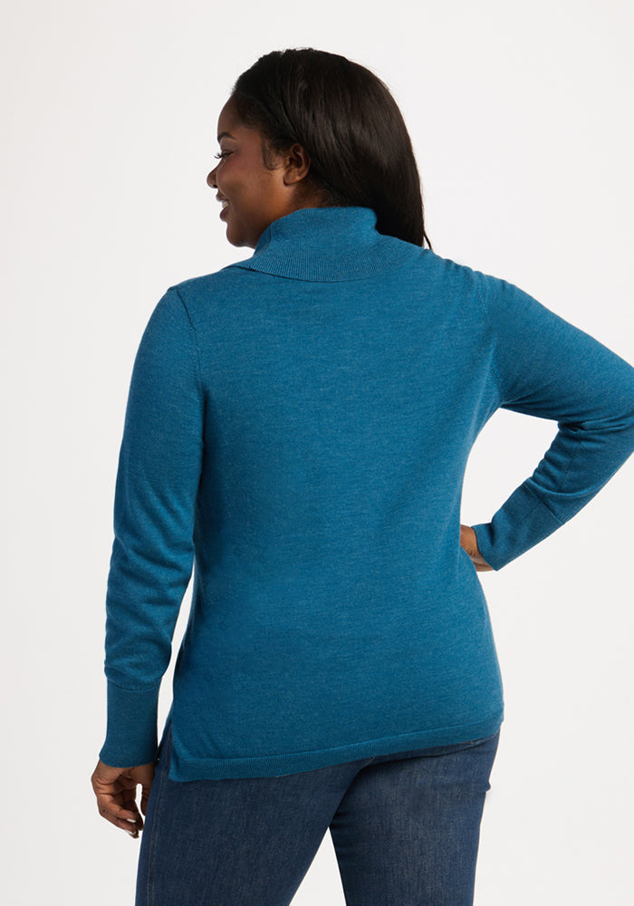 Woman facing away in a Woolx Josie Cowl Neck Sweater - Blue Pine and dark jeans, on a plain white background.