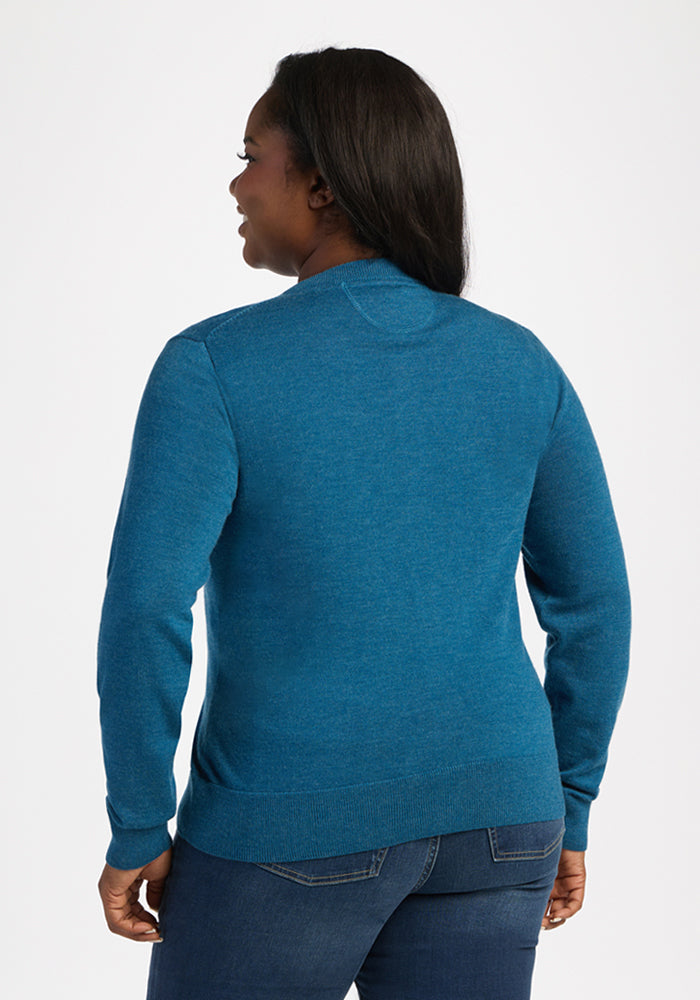 Woman facing away in Woolx Caitlin Sweater - Blue Pine and jeans, set against a plain white background.