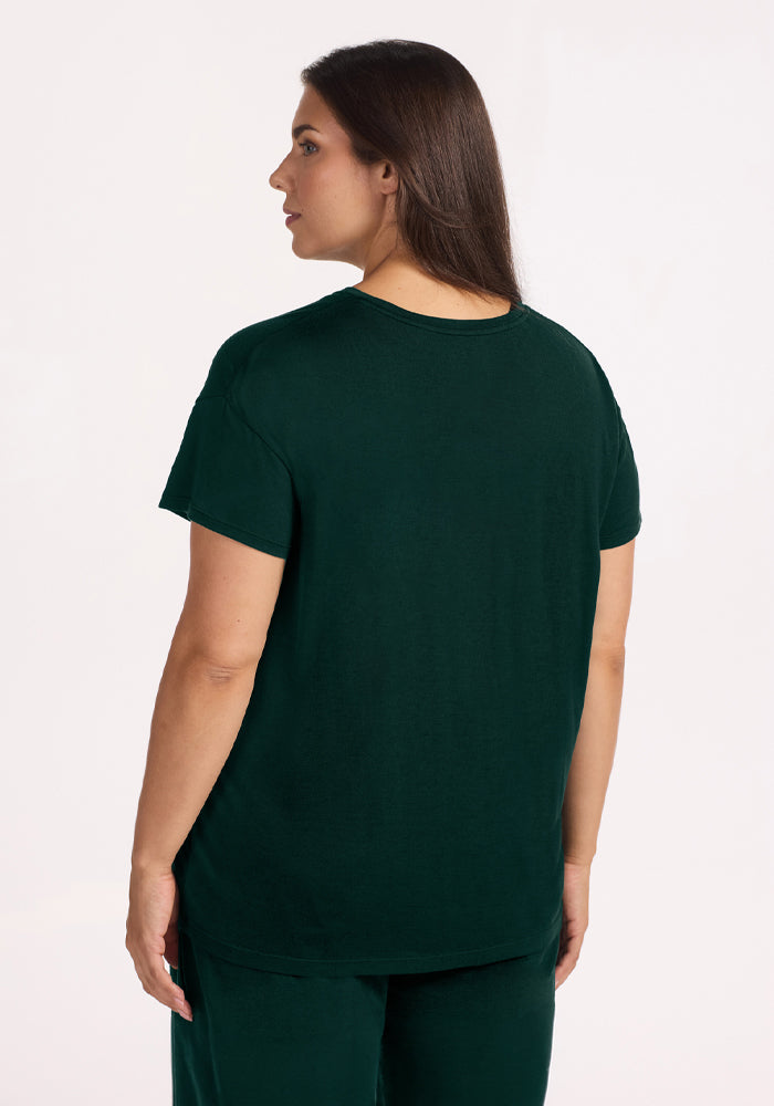 A person viewed from behind wearing a short-sleeved dark green Billie Lounge Tee - Deep Pine moisture-wicking crewneck.