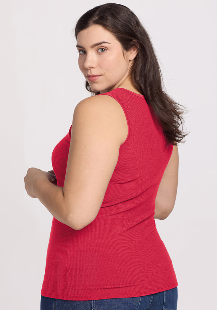 Woman in the Woolx Vivi Ribbed Tank in Berry Ice Pop and blue jeans, long dark hair, looks over her shoulder.