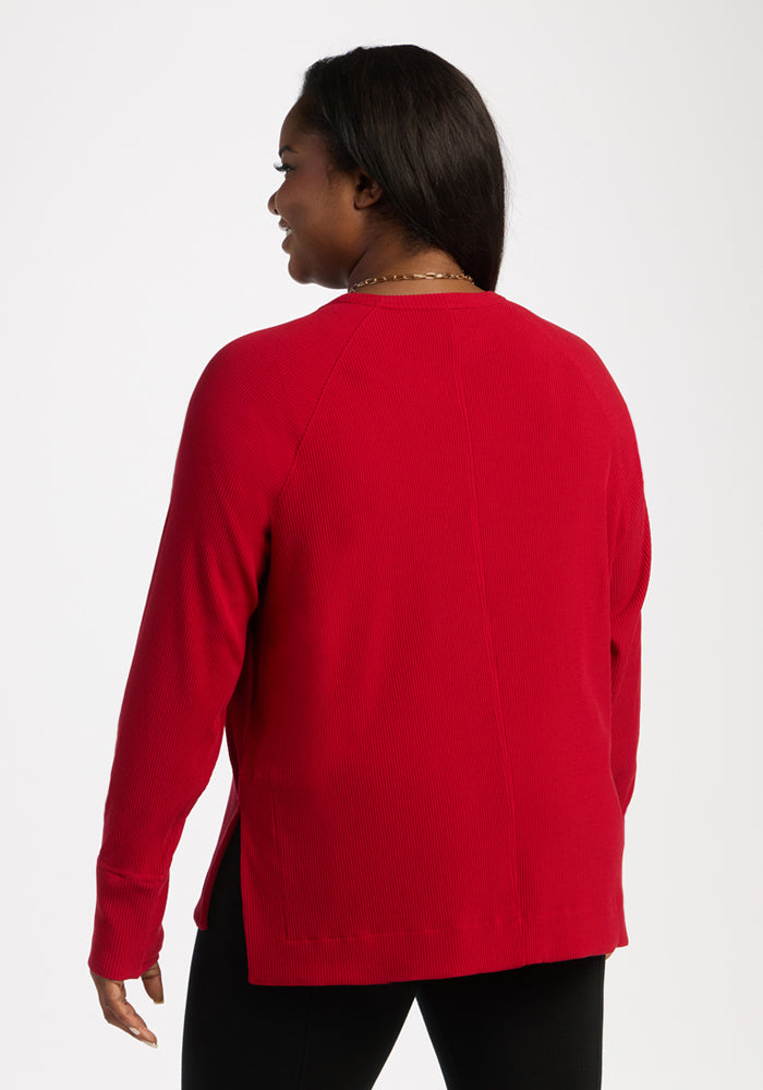 Woman facing away in Woolx Ainsley Sweater - Maraschino Cherry and black pants, on a plain white background.