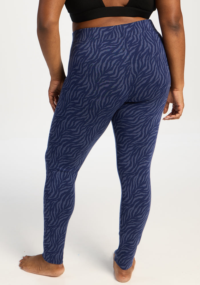 Person barefoot, seen from behind in Woolx Taylor Baselayer Leggings - Midnight Safari (blue zebra stripes).