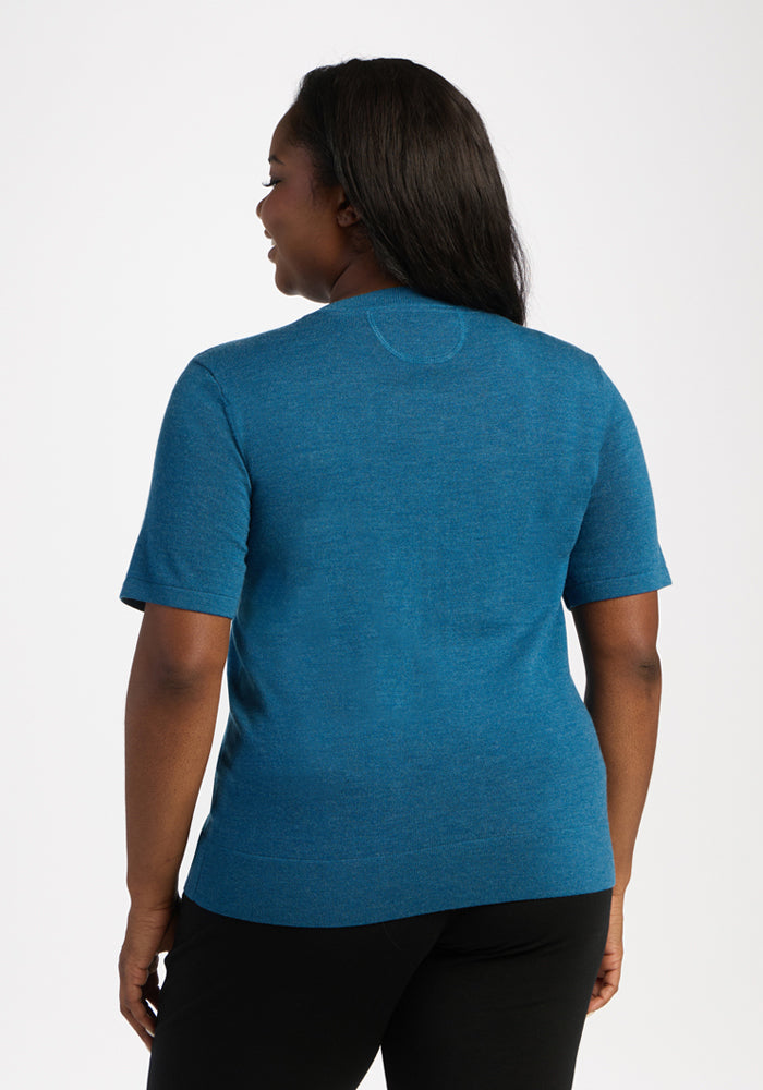 Woman wearing Woolx Anna Crew Sweater in Blue Pine, short sleeves, facing away on a white background.