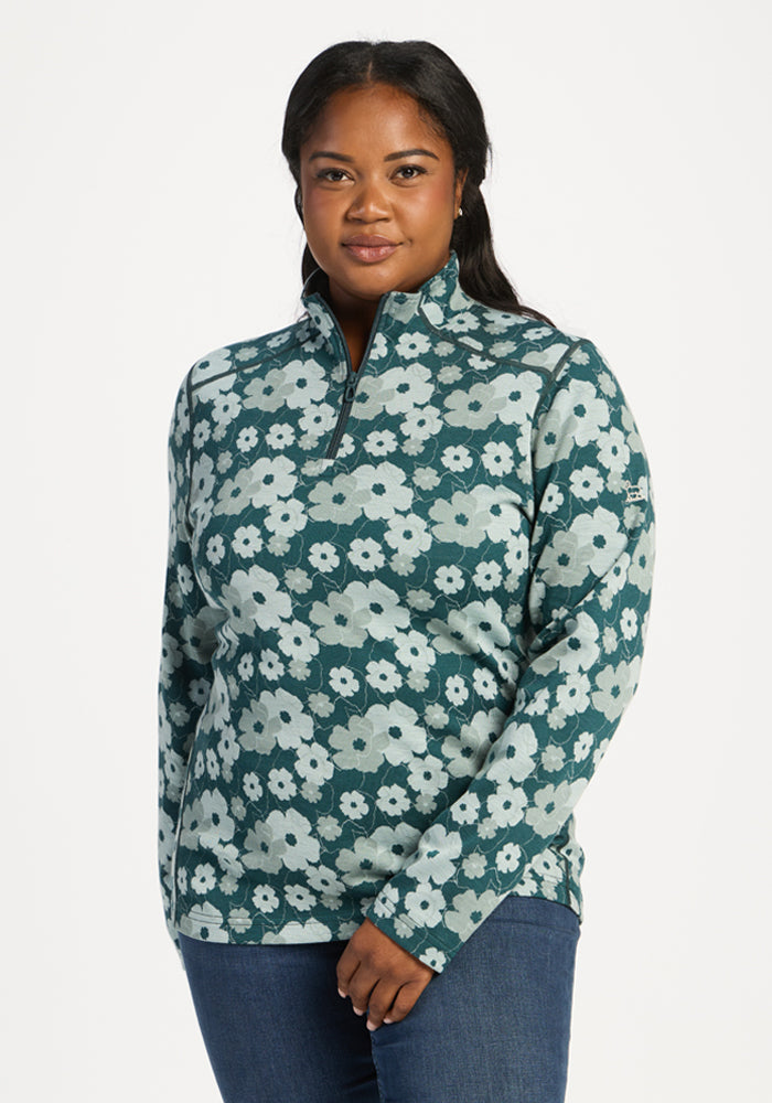 Woman wearing Woolx Emi 1/4 Zip - Coastal Wildflower, featuring moisture-wicking fabric, on white background. 