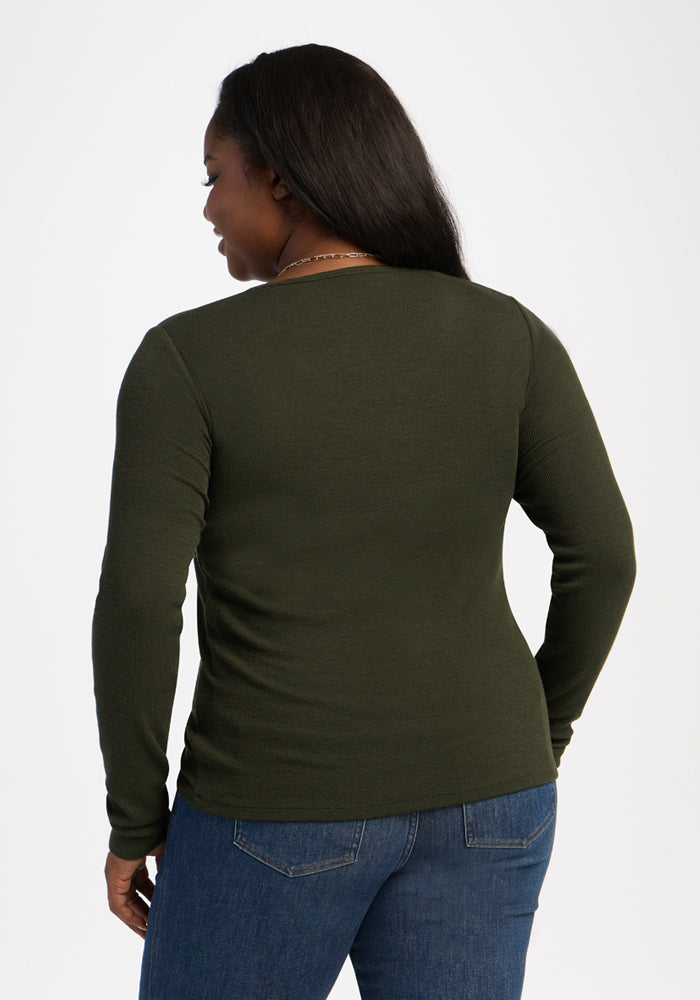 A woman wears the Woolx Katie Ribbed Long Sleeve in Duffel Bag and jeans, facing away from the camera.