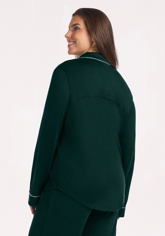 A person wears a Deep Pine Woolx Harper FeatherTouch® Pajama Set top with light-colored piping on the collar and cuffs.