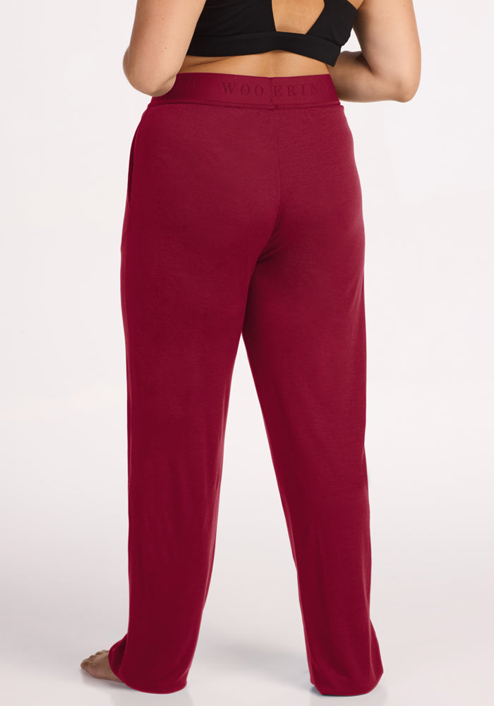 Back view of a person wearing beet red, wide-leg Woolx Maya Lounge Pants with an elastic waistband.