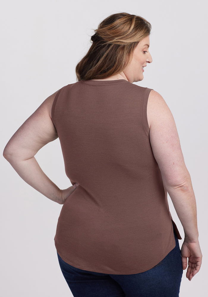 Woman with light brown hair in a Woolx Bella Tunic Top - Peppercorn and blue jeans, shown from the back, smiling.