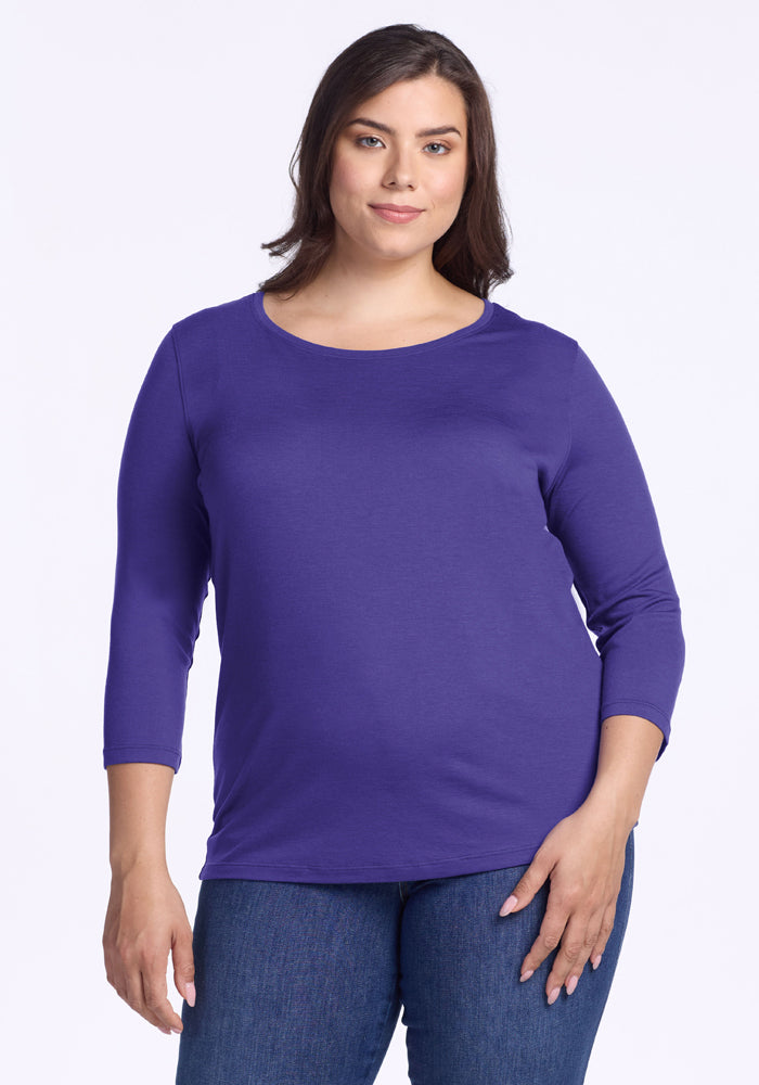 Woman in a Woolx Jenny 3/4 Sleeve Crew Neck - Berry Indigo and blue jeans, standing against a white background. 