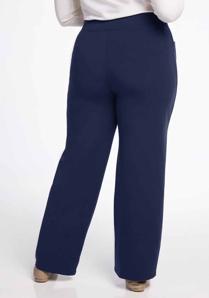 Model wears Woolx Ellie Wide Leg Pants in Ocean Cavern with beige shoes, shown from the back on a white background.