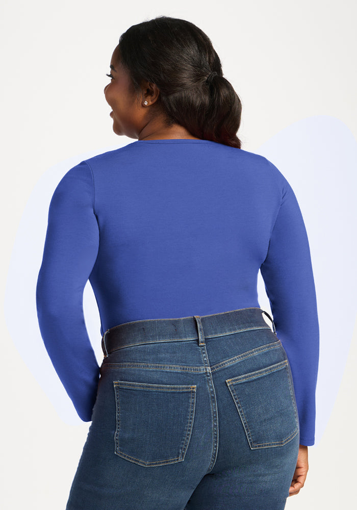 Woman in Woolx Margot Bodysuit - Royal Blue and jeans, seen from the back against a light background.