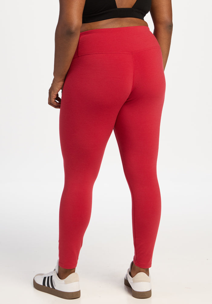 Back view of a person wearing bright red Angela Leggings - Maraschino Cherry and white sneakers with black stripes.