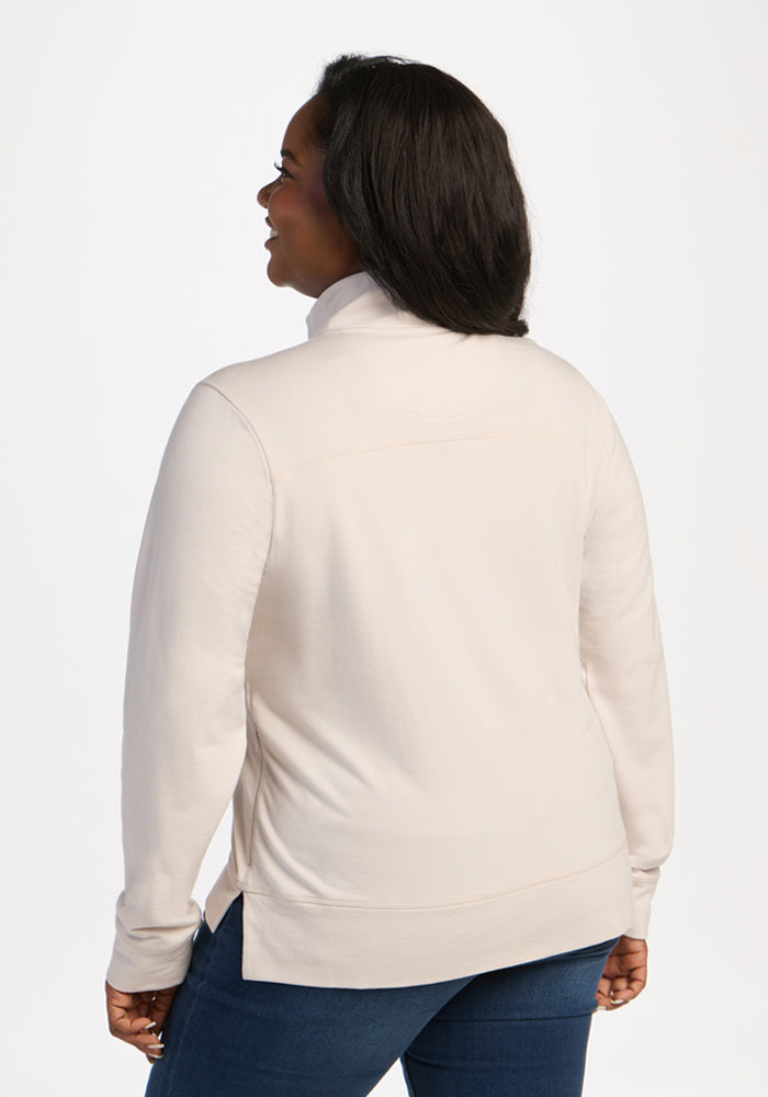 Woman in Woolx Annie 3 Button Pullover - Ecru and blue jeans stands with her back to the camera, glancing back.