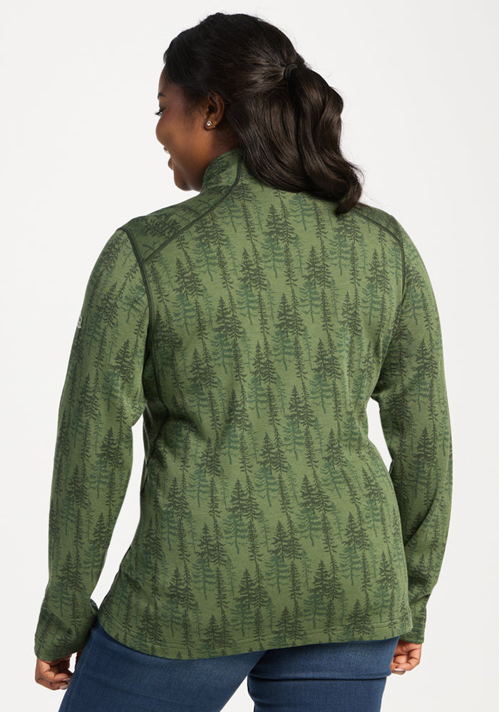 Woman in Woolx Emi 1/4 Zip – Forest Friends, featuring a green tree print, seen from behind on white background.