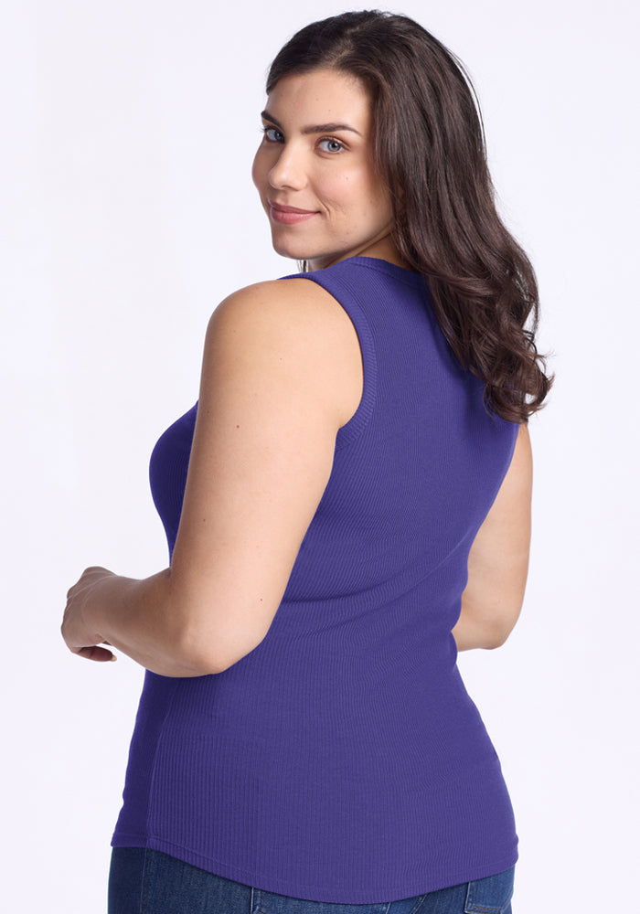 Woman in Woolx Raegan Ribbed Tank Top - Berry Indigo and blue jeans, smiling over her shoulder.